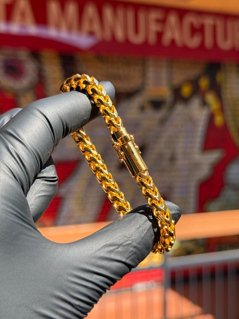 Gold bracelet displayed by hand at TA Jewelers