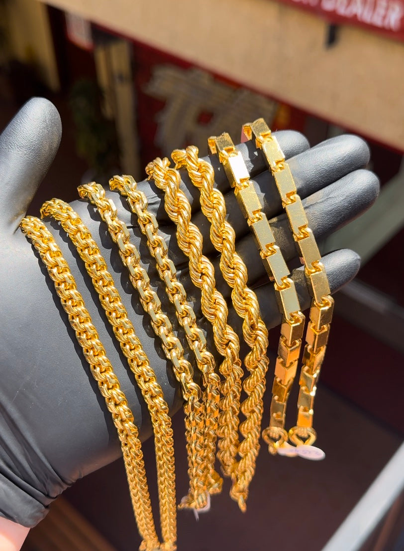 TA Jewelers gold necklaces displayed by hand