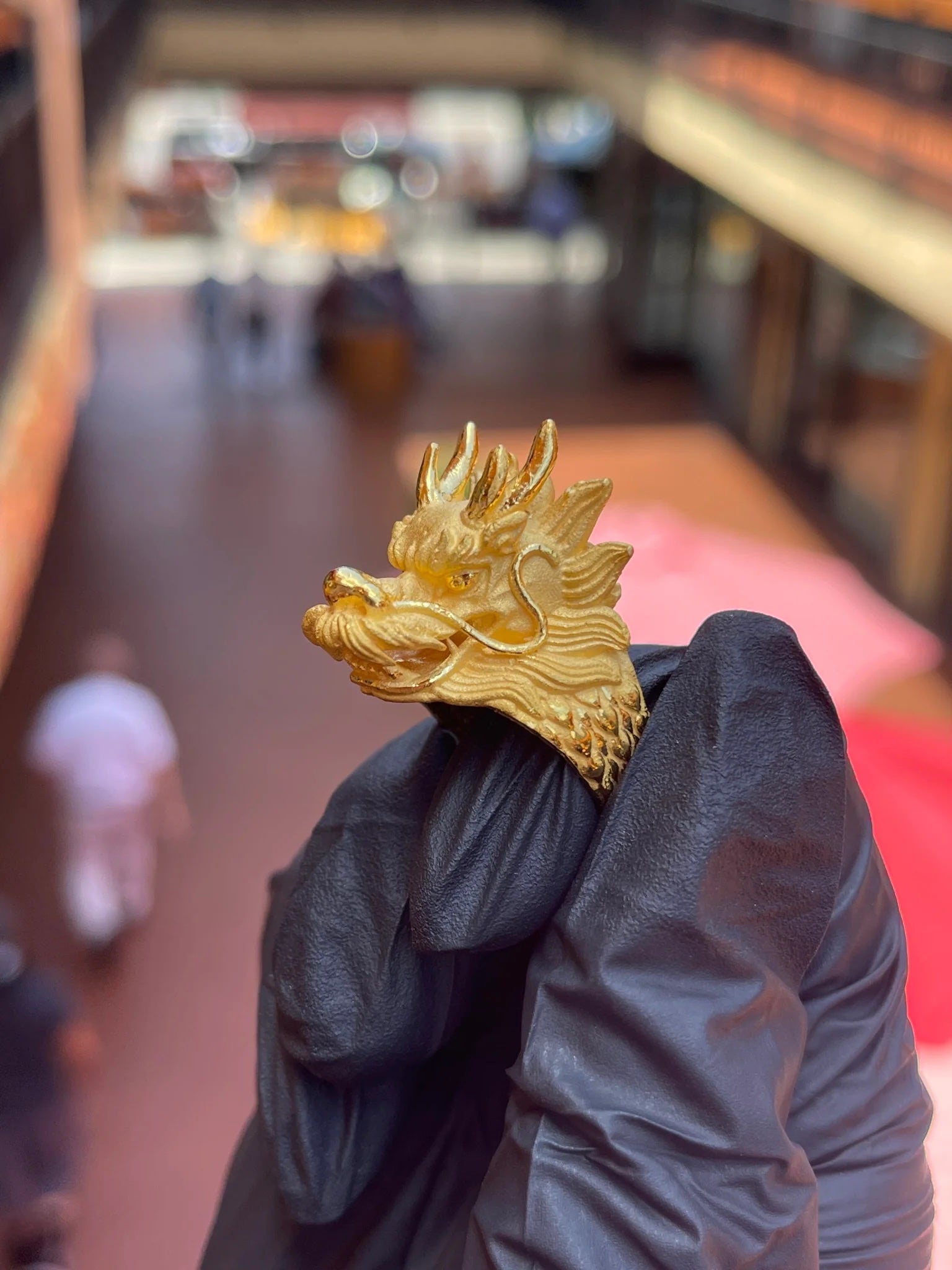 Gold dragon ring displayed by hand at TA Jewelers